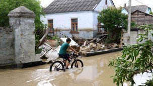 Мальчик на велосипеде в подтопленном поселке