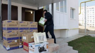 Мужчина заселяется в новый дом рядом вещи
