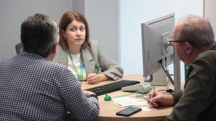 Специалистка с посетителями в офисе банка