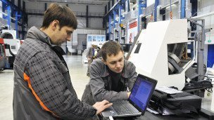 Сотрудники с ноутбуком на заводе