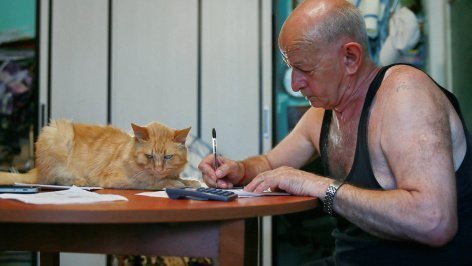 Мужчина заполняет квитанцию жилищно-коммунальных услуг