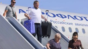 пассажиры выходят из самолета по трапу