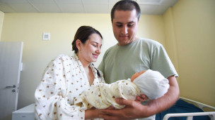 Молодые родители с новорожденным ребенком