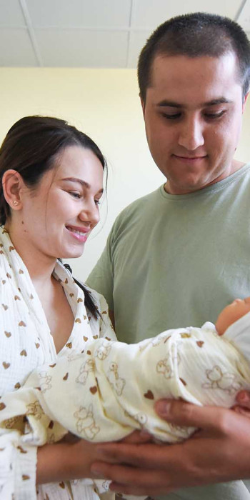 Молодые родители с новорожденным ребенком