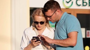 Горожане возле отделения банка со смартфоном 