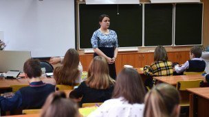 Учитель в классе ведет урок 
