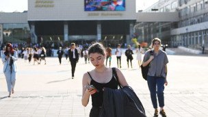 Девушка с телефоном около университета