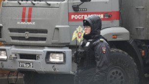 Сотрудник полиции у машины с надписью "Росгвардия"