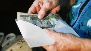 Пожилая женщина с российскими деньгами в руках