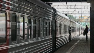 Пассажир у поезда дальнего следования на вокзале