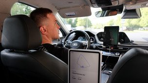 Водитель-испытатель, который следит за безопасностью поездки в беспилотном такси