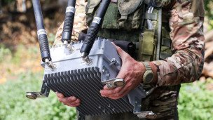 Военнослужащий бригады во время установки модуля РЭБ