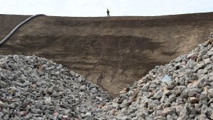 Щебень в карьере на фоне идет человек