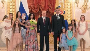 Президент РФ Владимир Путин в центре и многодетная семья