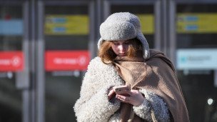 Девушка с телефоном у выхода со станции метро