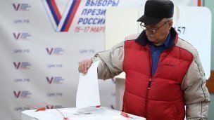 Мужчина голосует на выборах президента России 