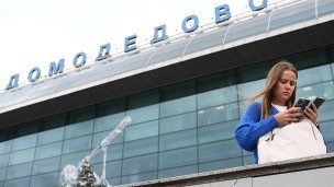Девушка с телефоном в аэропорту Домодедова