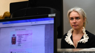 Девушка фотографируется для получения водительского удостоверения