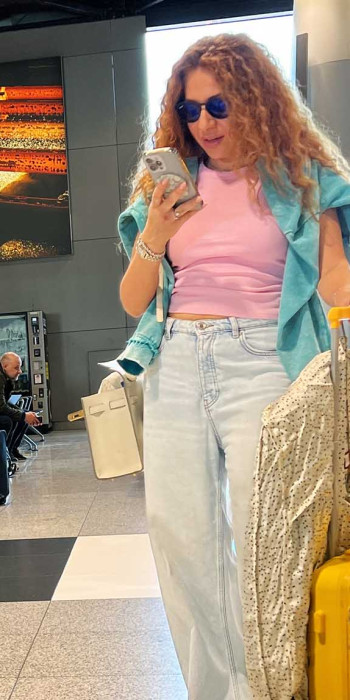 Женщина с телефоном и багажом в аэропорту