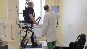 Пациент занимается на роботизированном комплексе для улучшения функций нижних конечностей и восстановления навыков ходьбы
