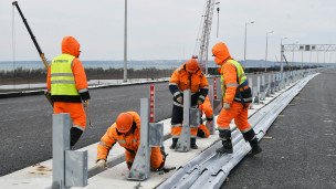 рабочие во время дорожных работ на мосту
