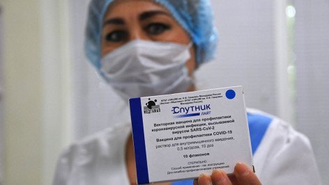 Медицинская работница демонстрирует упаковку с вакцинами "Спутник Лайт"