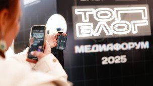 Девушка фотографирует бейдж на фоне баннера топблог