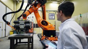 Сотрудник управляет роботизированной установкой