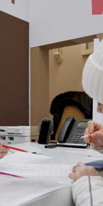 Жительница Мариуполя заполняет документы в отделении многофункционального центра