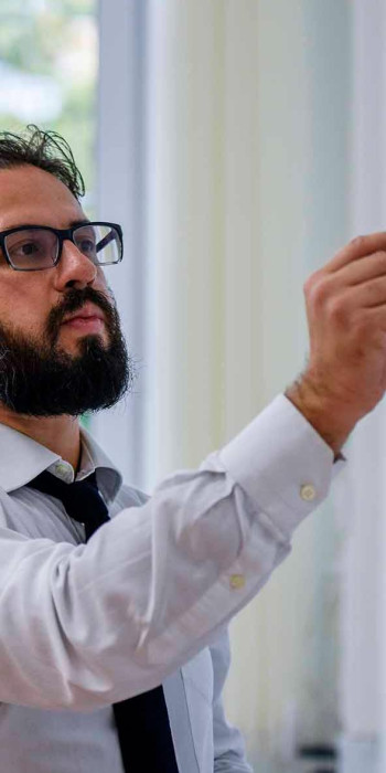 молодой ученый пишет на доске маркером