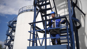 Сотрудник в каске на нефтеперерабатывающем заводе