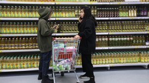 Покупатели у полок с растительным маслом в магазине