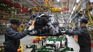 Рабочие за сборкой автомобиля