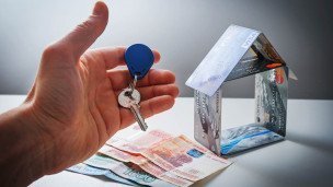 Ключ, деньги и домик, сложенный из банковских карт