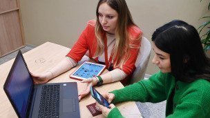 Две девушки работают за компьютером 