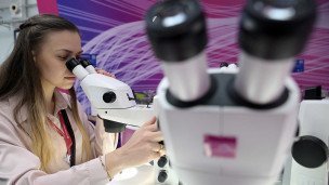 Девушка смотрит в микроскоп