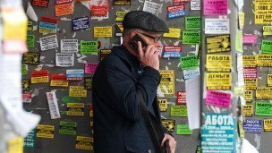 Muzhchina-s-telefonom-na-odnoy-iz-ulits-goroda