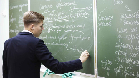 Ученик старших классов пишет на доске