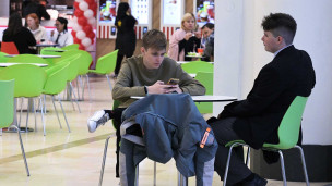 Молодой человек с телефон в кафе