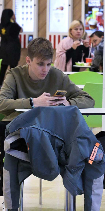 Молодой человек с телефон в кафе