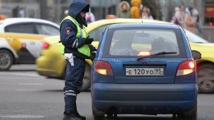Сотрудник ДПС  у автомобиля на дороге