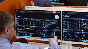 Мужчина за компьютером с облигациями