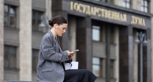 Девушка с телефоном на фоне здания Государственной думы