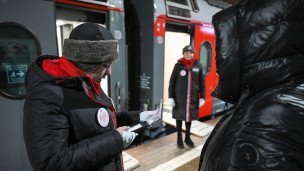 Проводница проверяет документы пассажира перед посадкой на поезд
