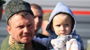 Военный мужчина с ребенком на руках