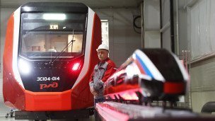 Сотрудник завода стоит у электропоезда