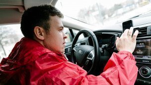Мужчина в автомобиле с мобильным телефоном