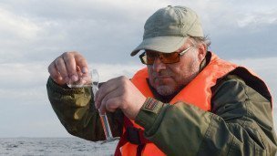 Научный сотрудник производит забор проб морской воды