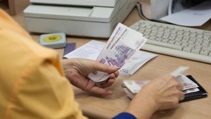 Сотрудница банка выдает пенсию