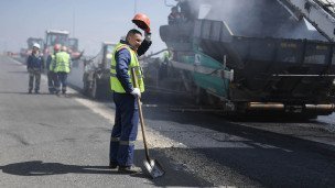 Рабочий снимает каску во время строительства дорог
